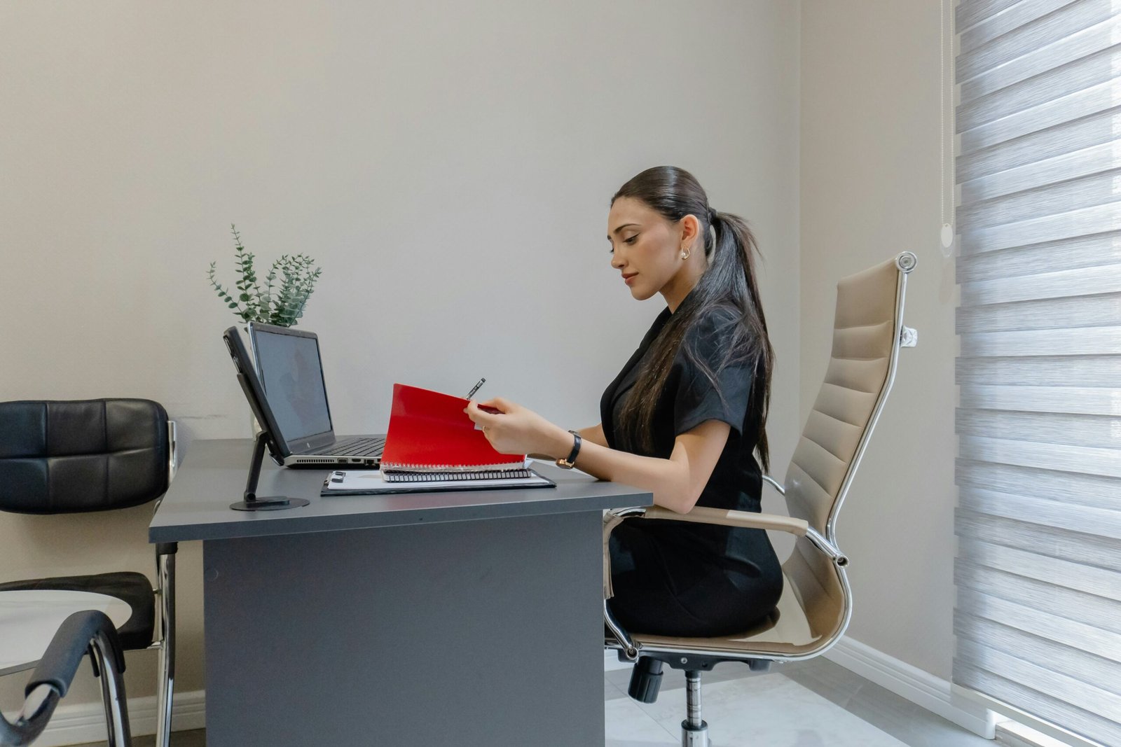 Person sitzt am Schreibtisch und blickt kurz vom Bildschirm weg.